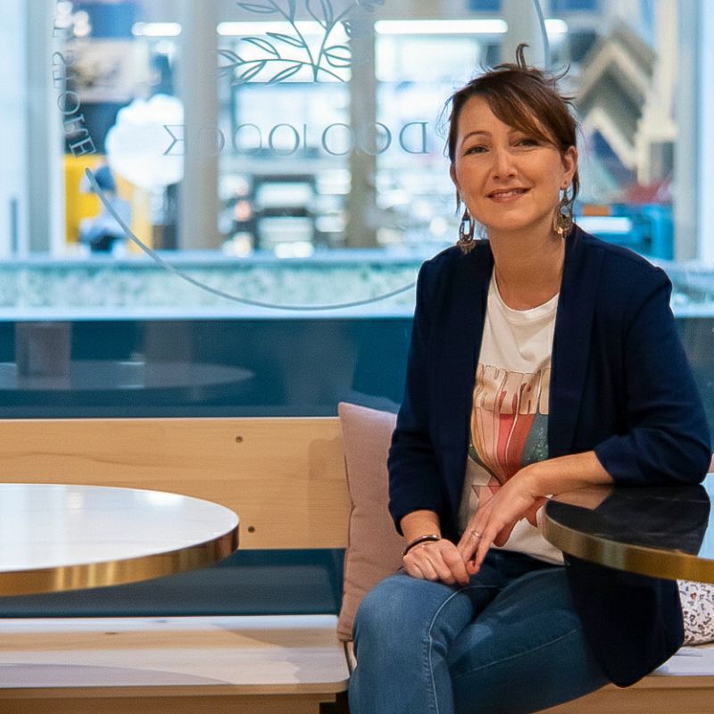 Élodie Castillo, fondatrice du studio web à Genève, assise dans un café - création de site internet WordPress Suisse romande